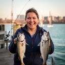 Arafa Yirenkyi smiling with a catch on a New York waterfront